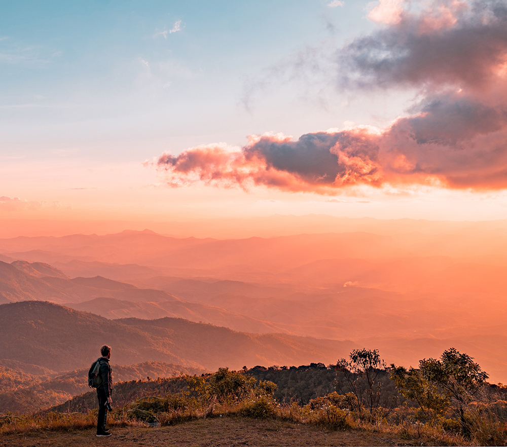 un randonneur avec coucher de soleil sur la montagne